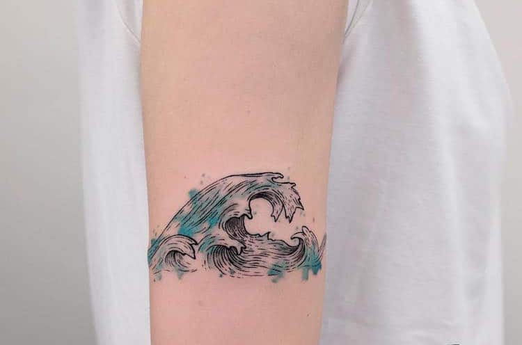 tatouage tendance - vague sur le haut du bras touches aquarelles