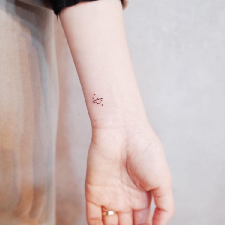 mini-tatouage discret planete minimaliste poignet