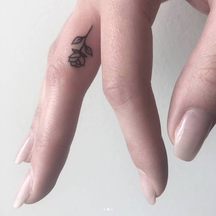 petit tatouage sur le doigt majeur rose minimaliste