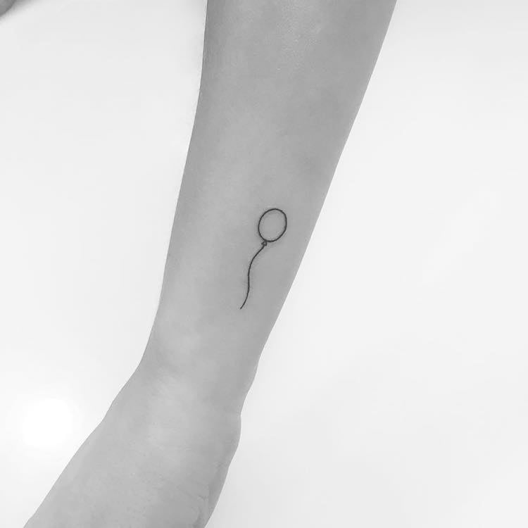 tatouage discret ballon minimaliste poignet