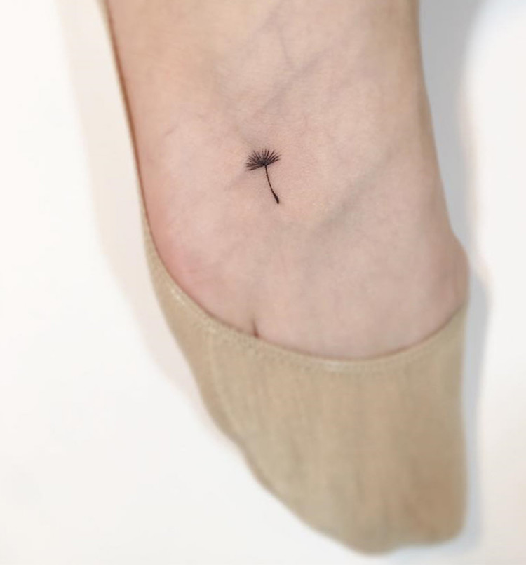 tatouage discret minimaliste pied fleur pissenlit