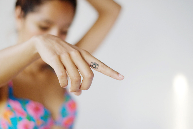 tatouage doigt appareil photo minimaliste
