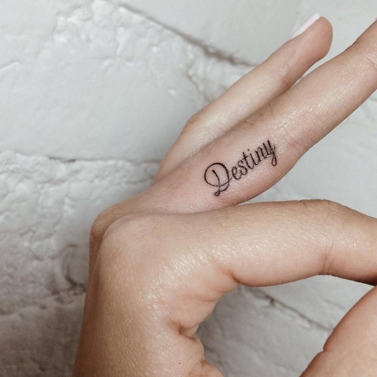 tatouage sur le doigt annulaire lettrage destin