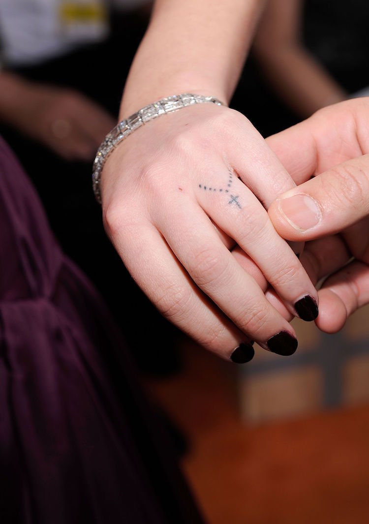 tatouage sur le doigt annulaire rosaire croix