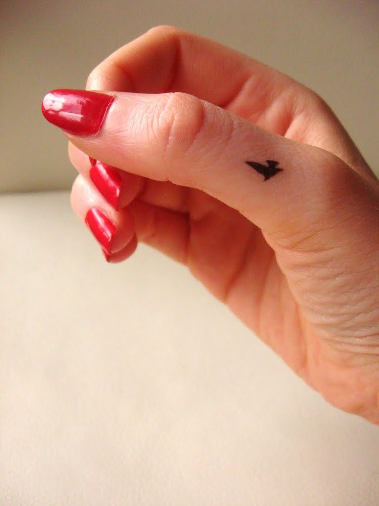 tatouage sur le doigt pouce oiseau noir