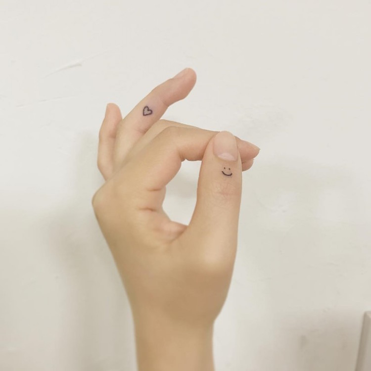tatouage sur le doigt visage souriant coeur