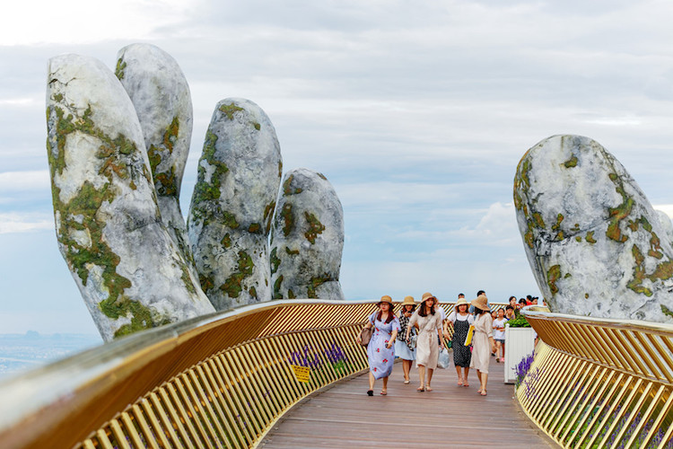pont doré Vietnam soutenu mains geantes