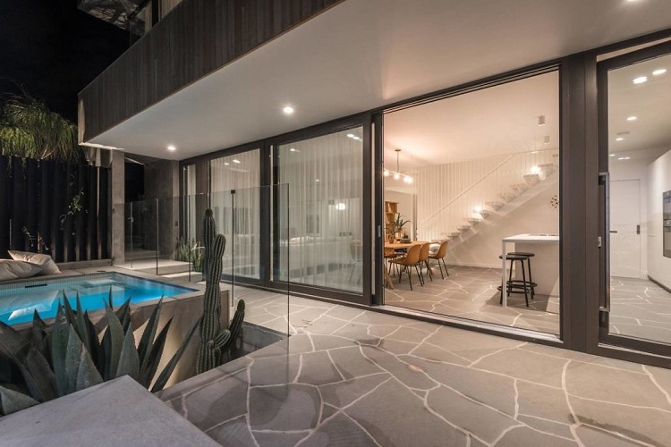 sol en béton maison moderne avec piscine fenêtres coulissantes