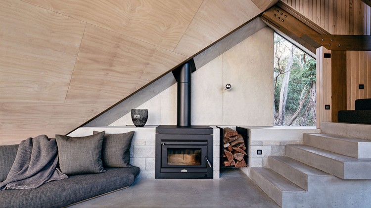 toit en pente intérieur cosy cheminée bois et béton