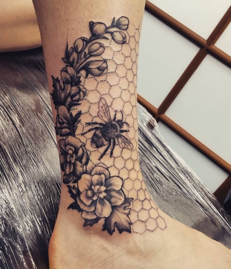tatouage abeille et nid d'abeille pied femme fleurs