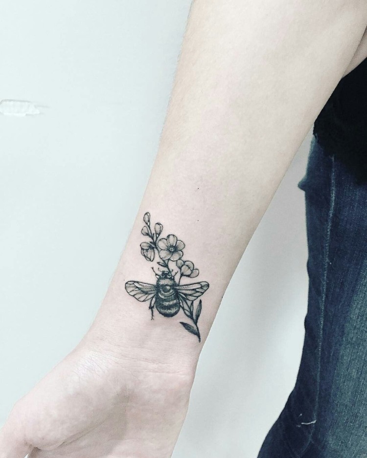 tatouage abeille et nid d'abeille sur le poignet fleur