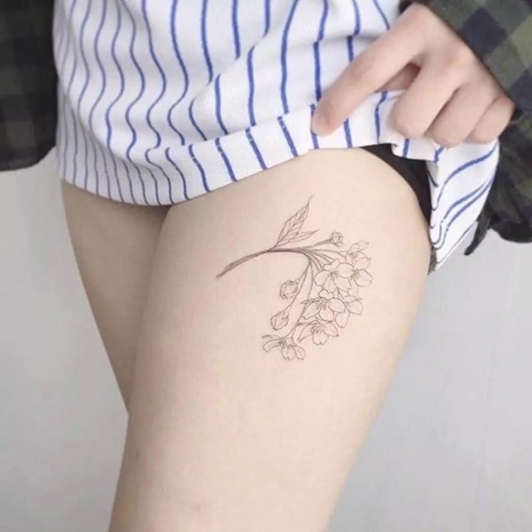 tatouage femme cuisse fleur minimaliste