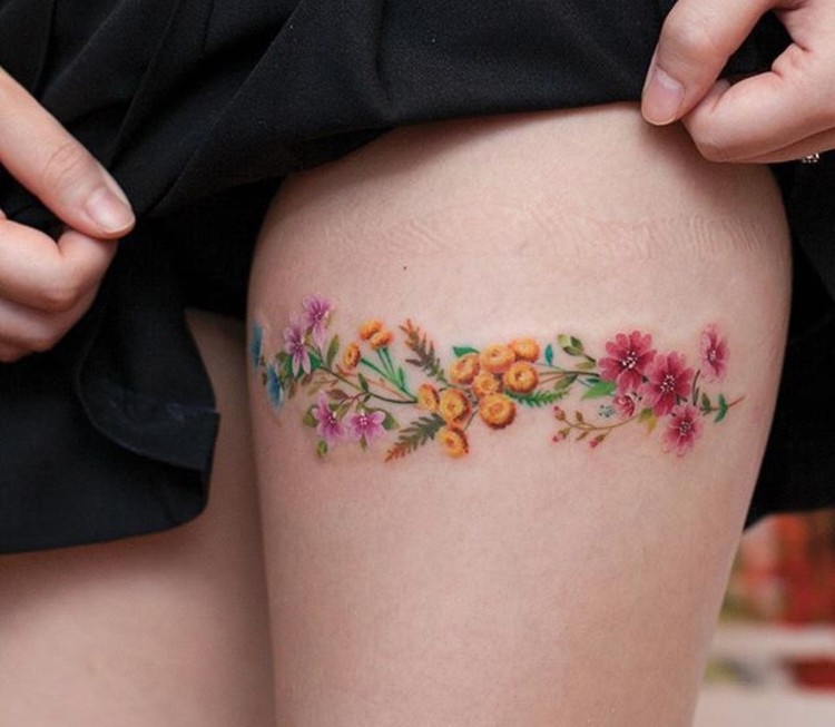 tatouage femme cuisse fleurs colorées effet bracelet