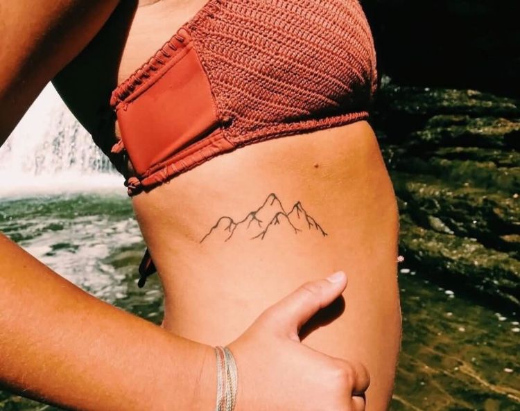 tatouage côte femme contours montagne idée minimaliste