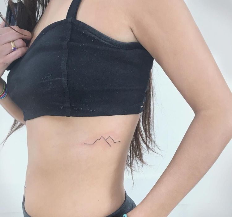 tatouage côte femme minimaliste contours montagne
