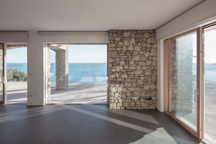 architecture en pierre naturelle intérieur minimaliste sol béton ciré grandes fenêtres