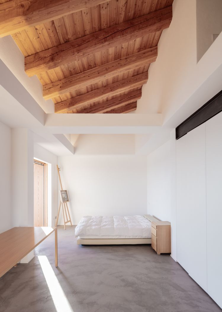 chambre à coucher minimaliste sol en béton ciré poutres de bois