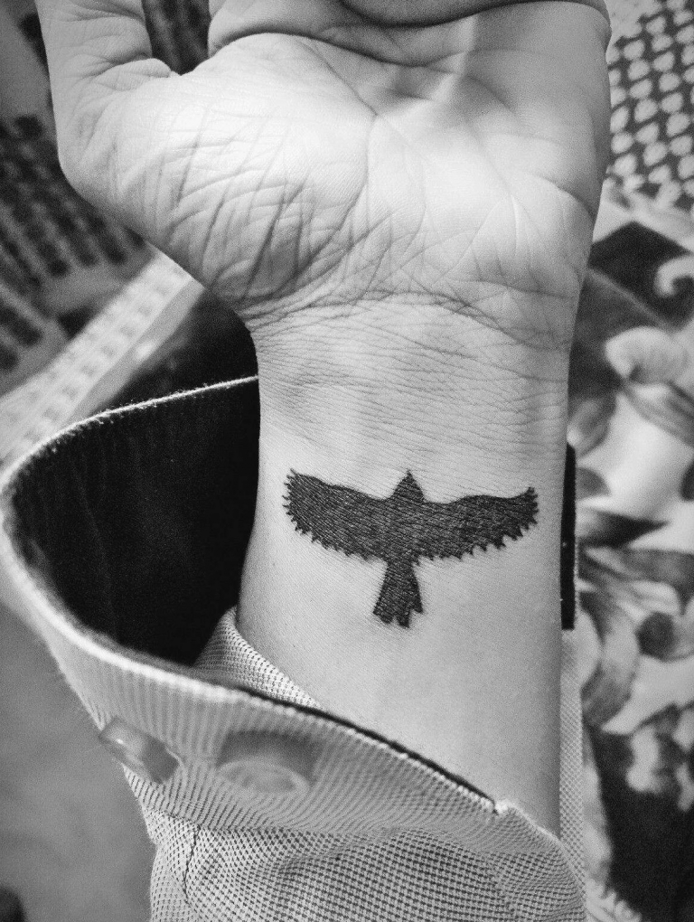 petit tatouage homme oiseau monochrome sur le poignet