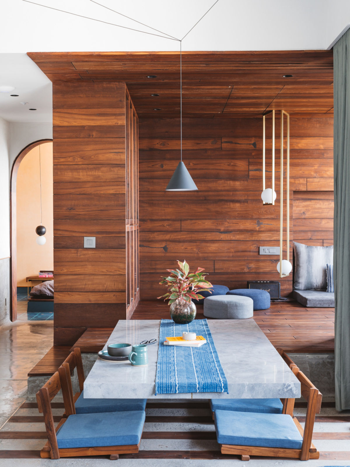 sol en béton poli habillage mural bois salle à manger suspension minimaliste