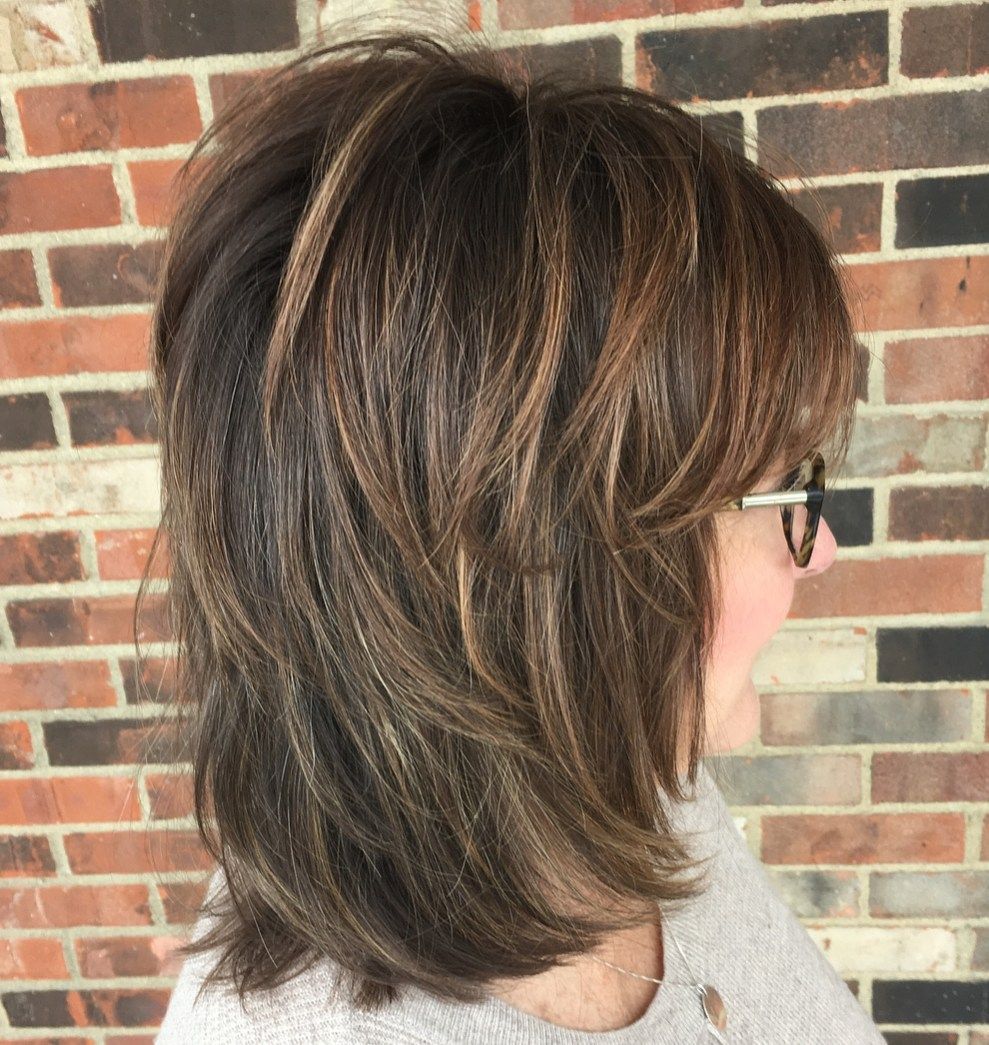 Hairstyle of a 50-year-old woman wearing glasses that highlights trend ideas
