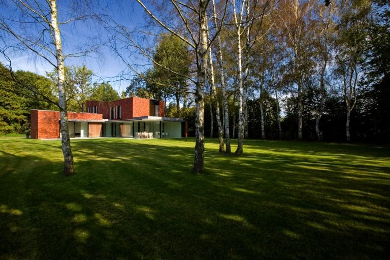 façade en brique rouge grandes fenêtres paysage naturel forêt