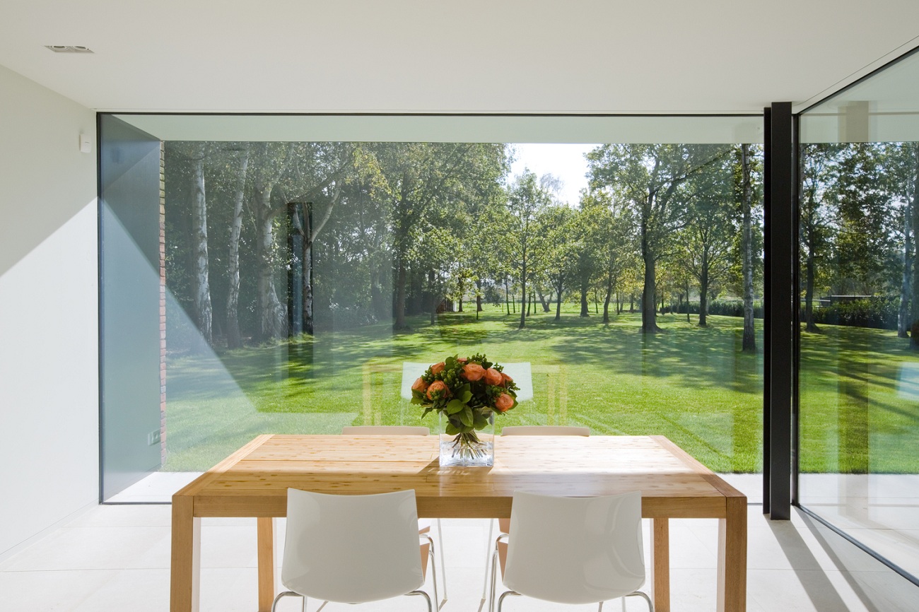 intérieur style minimaliste murs de verre table bois clair fleurs