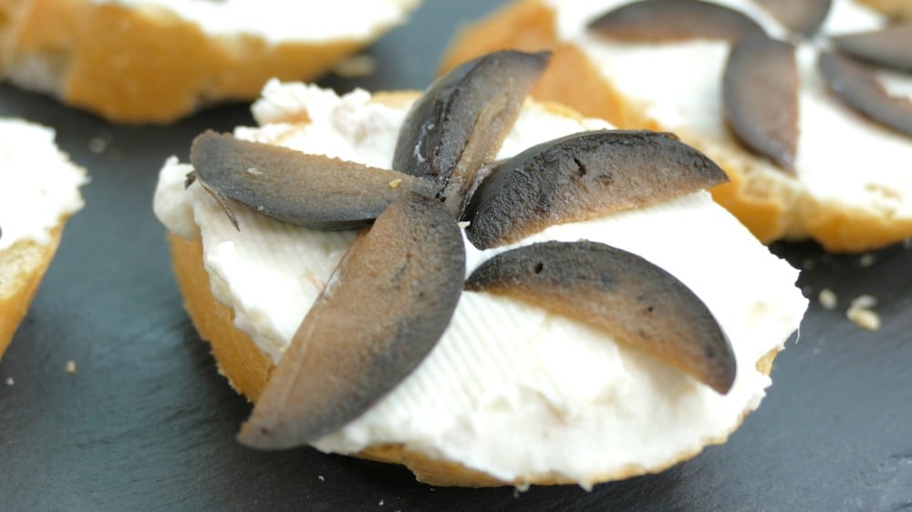 recette amuse-bouche facile bruschetta au fromage à la crème décorée d'olives