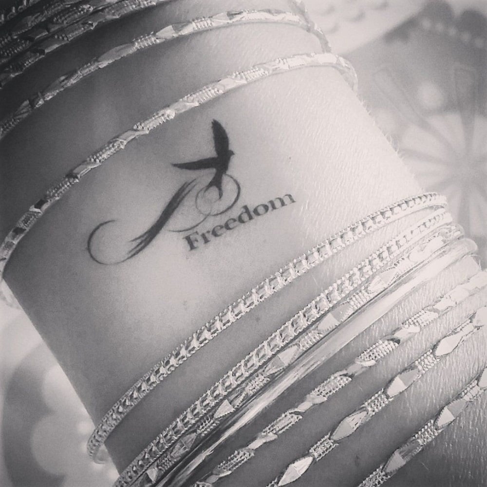 tatouage signification liberté écriture mot freedom avec hirondelle