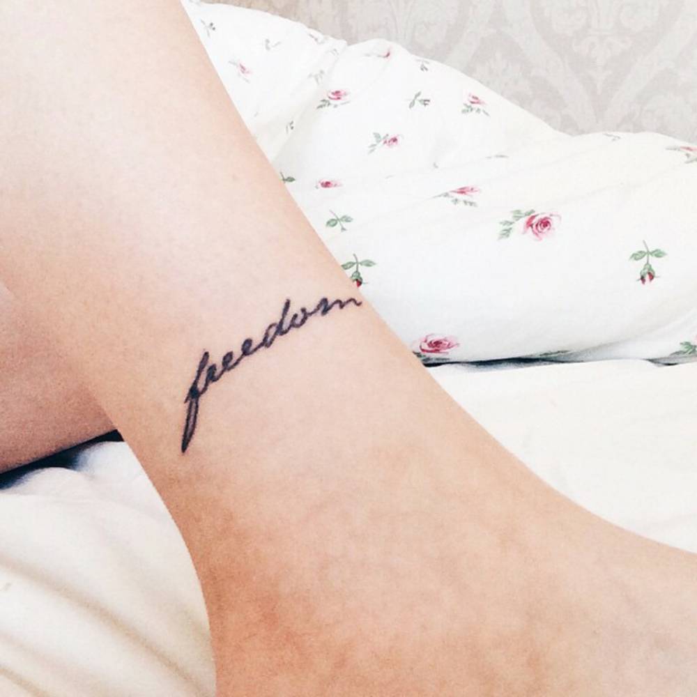 tatouage signification liberté écriture mot freedom cheville