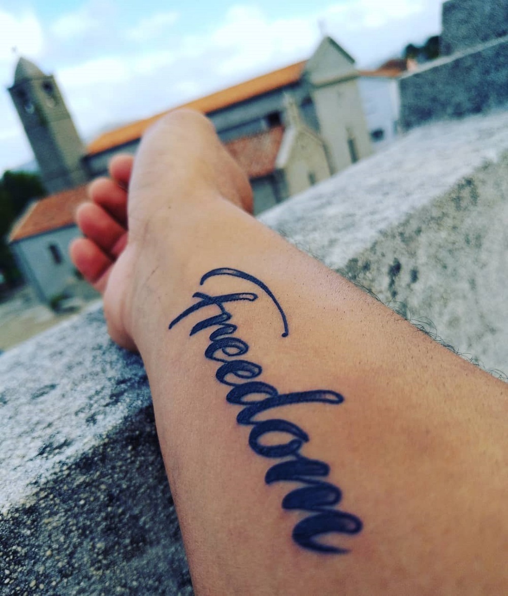 tatouage symbole liberté écriture bras original