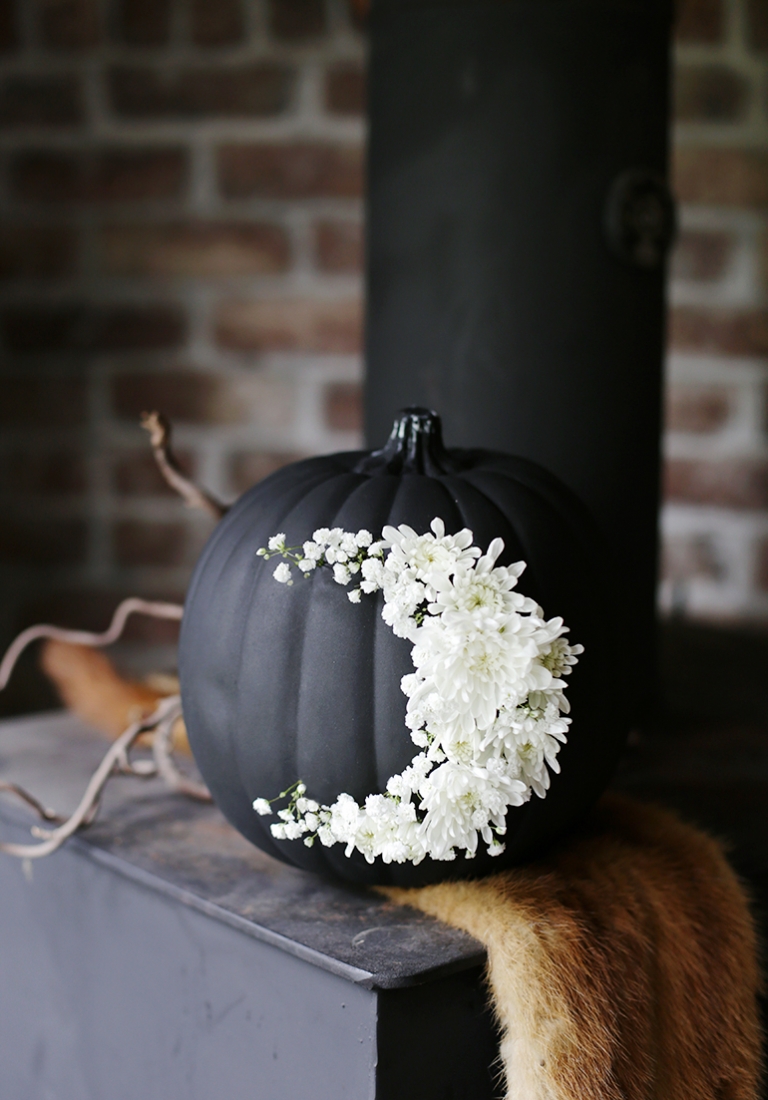 déco d'Halloween 2019 au style scandinave citrouille peinte noir avec fleurs blanches centre table chic