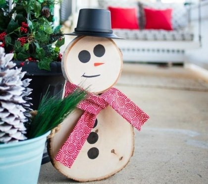 bonhomme de neige en bois avec une écharpe faite de feutrine rouge et un bonnet noir