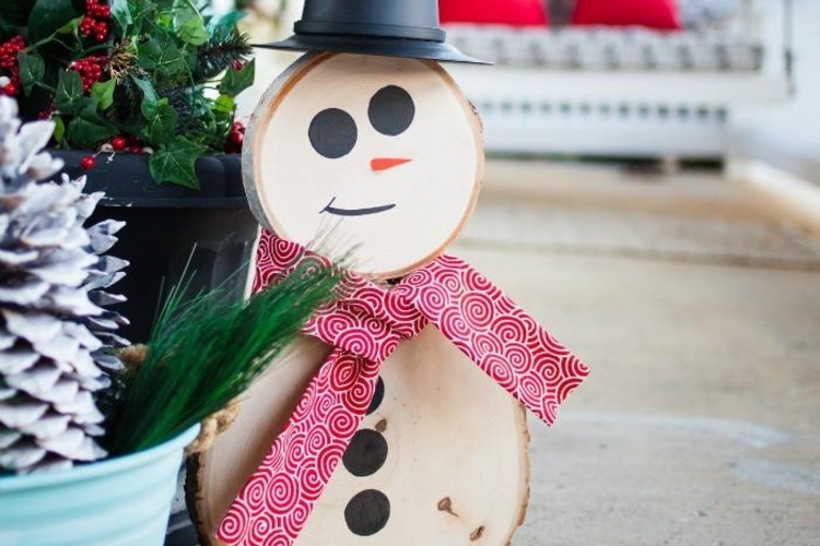 bonhomme de neige en bois avec une écharpe faite de feutrine rouge et un bonnet noir
