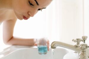 femme fait gargarisme bain de bouche naturel