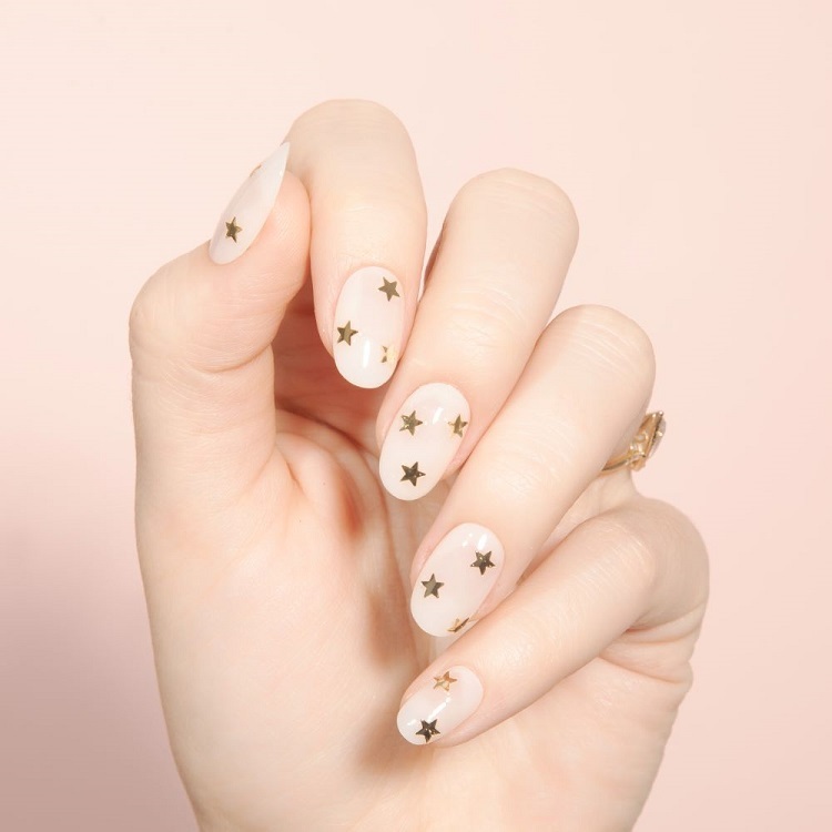 milky nails pour nouvel an tendance manucure laiteuse décorée motifs étoiles dorées