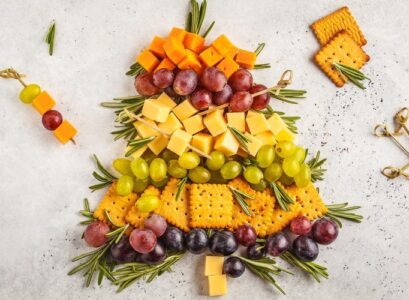 plateau de fromage en forme de sapin craquelins raisins romarin frais