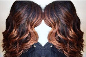 coloration balayage cuivré sur cheveux noirs ondulés