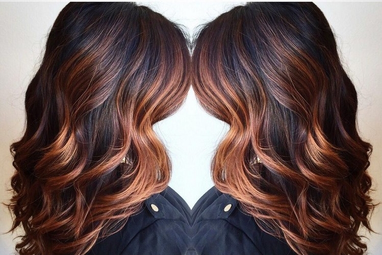 coloration balayage cuivré sur cheveux noirs ondulés