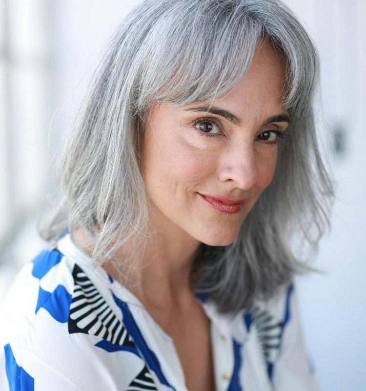 Care and hairstyles for natural gray and white hair of a 60-year-old woman