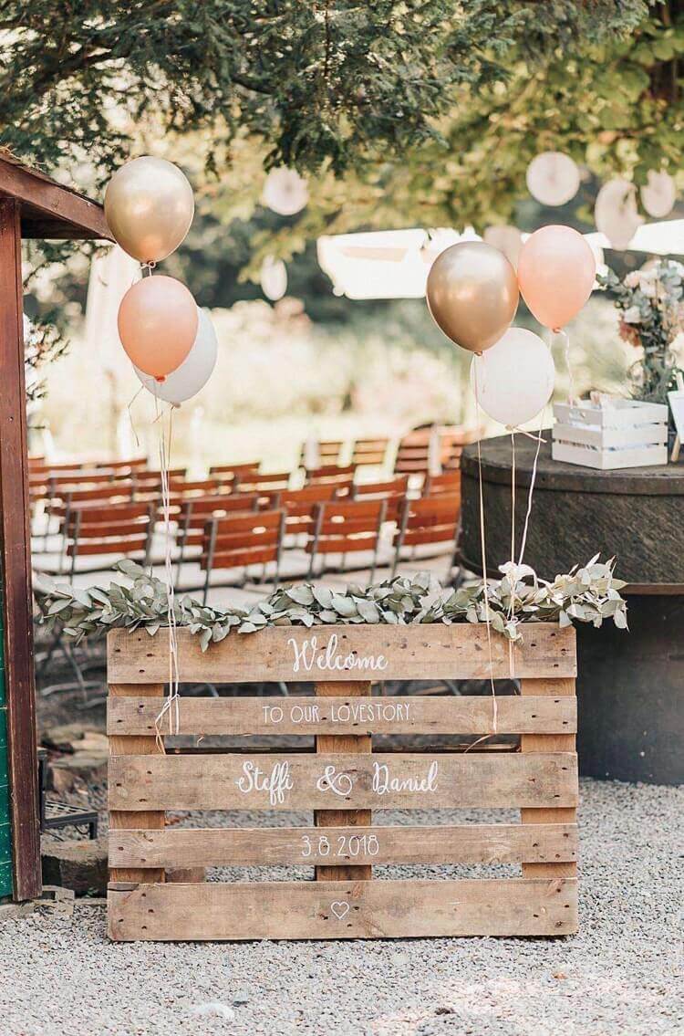 panneau de bienvenue mariage avec palette de bois déco guirlande de feuilles ballons