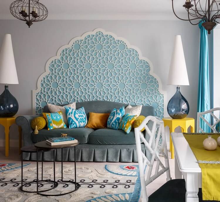 salon marocain en bleu et jaune avec une décoration murale qui imite les arcs de l'architecture marocaine