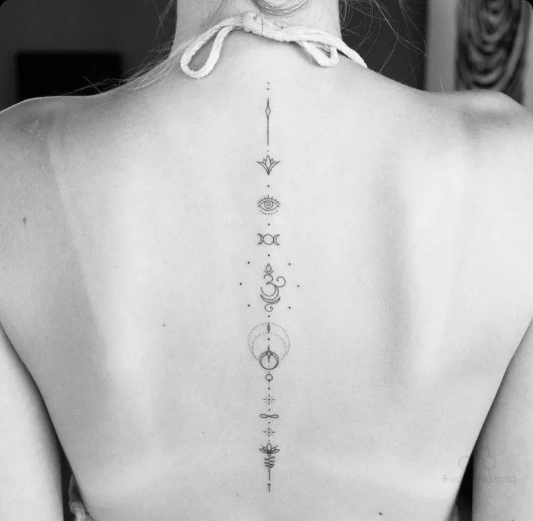 tatouage au dos femme modèle minimaliste fleurs de lotus symboles tattoo infini