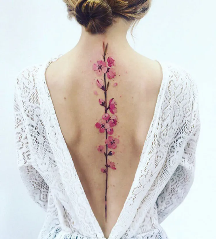 tatouage colonne vertebrale femme fleur de cerisier dessin romantique coloré