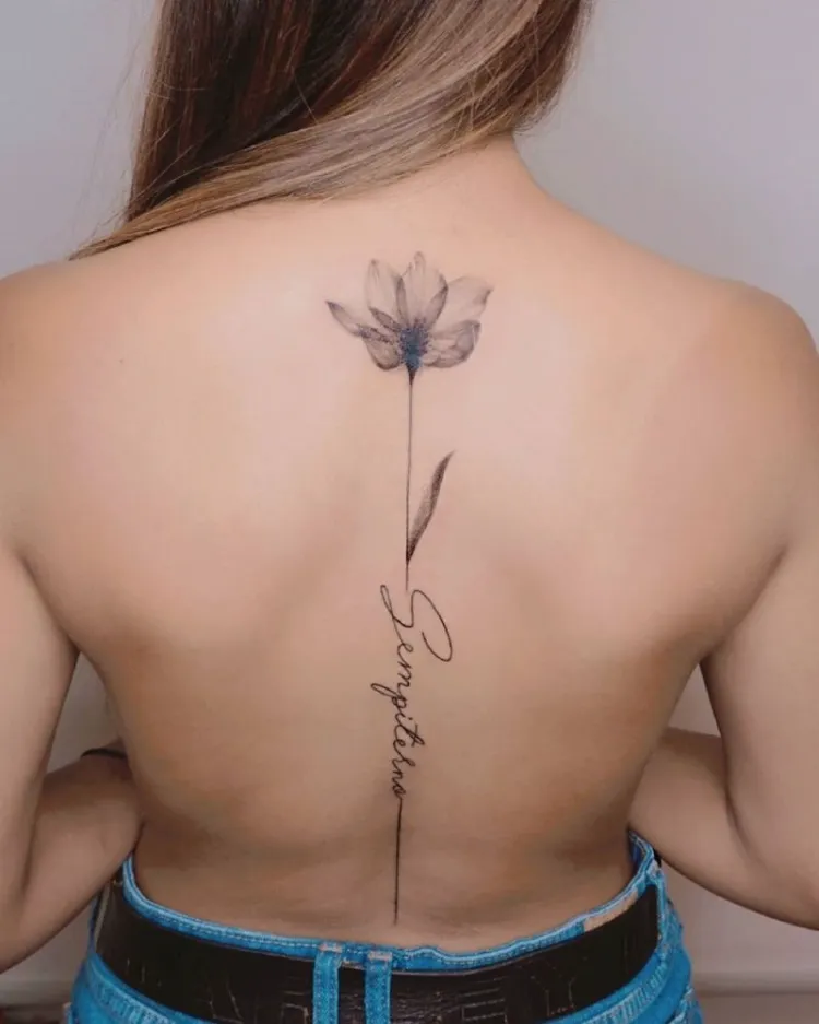 tatouage colonne vertebrale fleur accompagnée d'inscription idée délicate femme