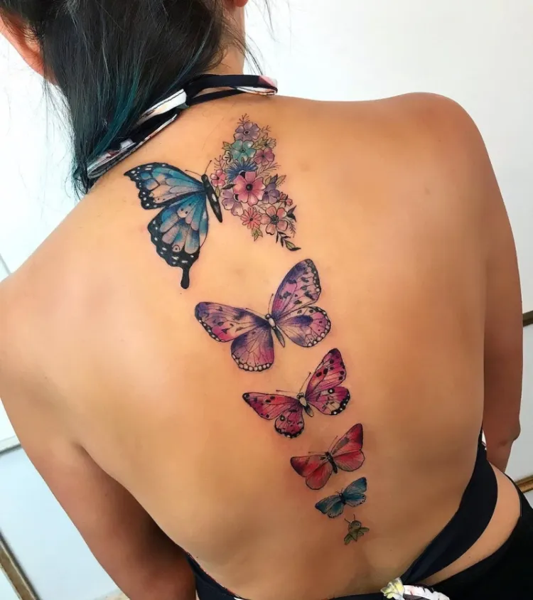 tatouage femme colonne vertébrale plusieurs papillons colorés