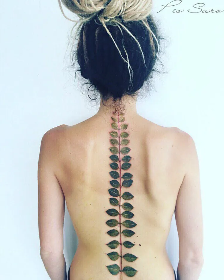 tattoo colonne vertebrale femme idée audacieuse une longue branche verte
