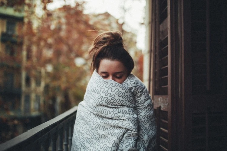 femme reste sous le couvertures pendant le rhume