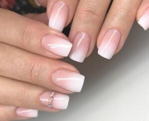 manucure américaine courte dégradée base nude blanc strass annulaire