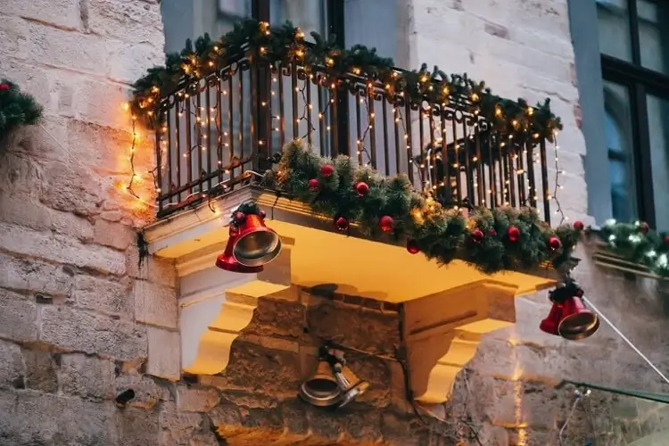 décoration de balcon pour Noel avec guirlandes de sapin artificiel boules de Noel cloches et guirlandes lumineuses