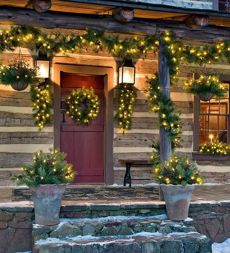 décoration de porche pour Noel avec des guirlandes de sapin et guirlandes lumineuses solaires